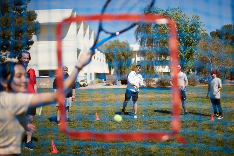 group of students playing on field seen through the net they're using