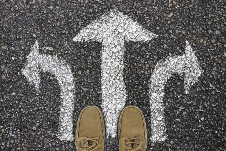 person standing with choice to go left, right, or straight